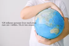 Photo of a person in a white t-shirt holding a large globe