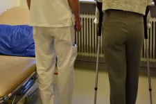 Two persons, one doctor and one "patient" trying to walk after surgery